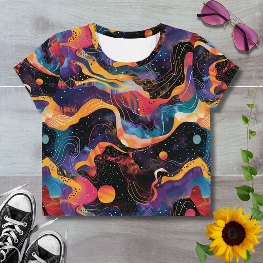 Women's all over print cropped t-shirt. Swirly galaxy patterns in orange, purple and reds across black starry sky